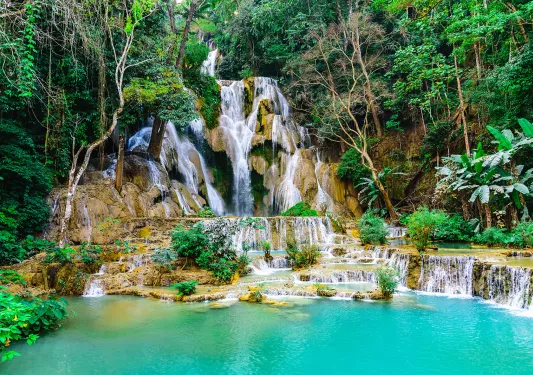 Large active waterfall with a small lake in front