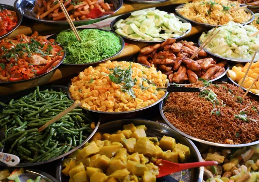 Large plates of noodles and cooked vegetables
