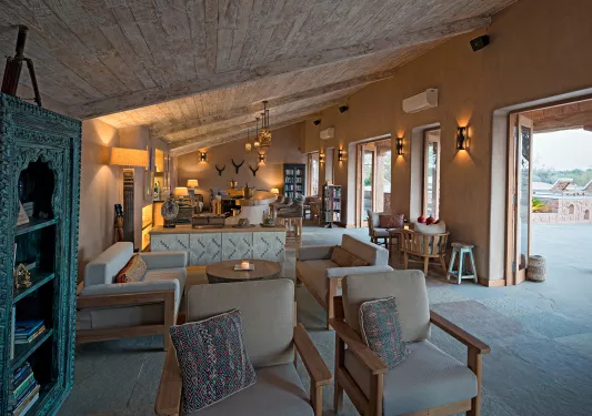 Roomed with cushioned chairs and large windows to the right