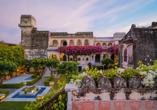 Exterior view of hotel building with flowers and an outdoor garden