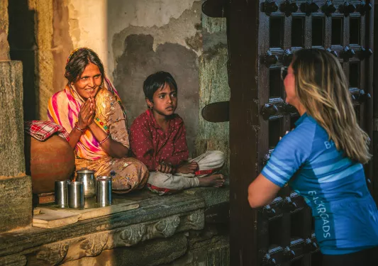 Woman bowing in front of another woman and her son