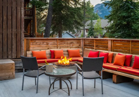 Outdoor patio with red cushioned chairs and a firepit