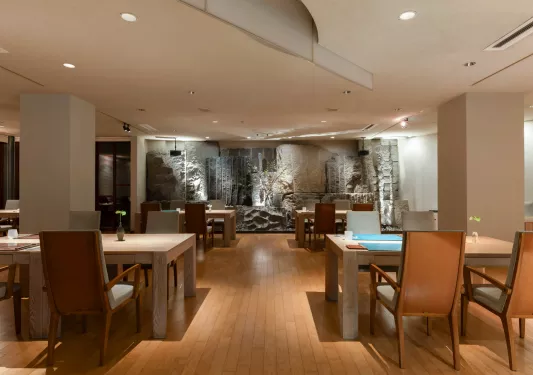 Lounge and seating area with large, wooden tables and cushioned chairs