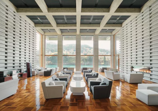 Large lounge with white and gray cushioned chairs surrounding white tables