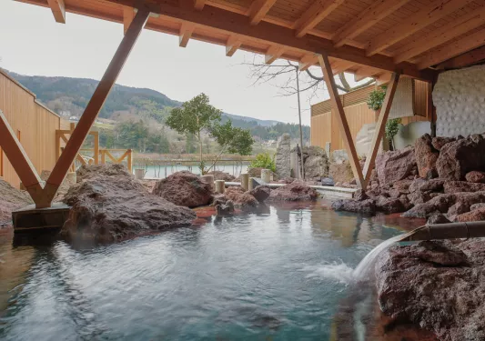 Outdoor sauna with large rocks and steaming water