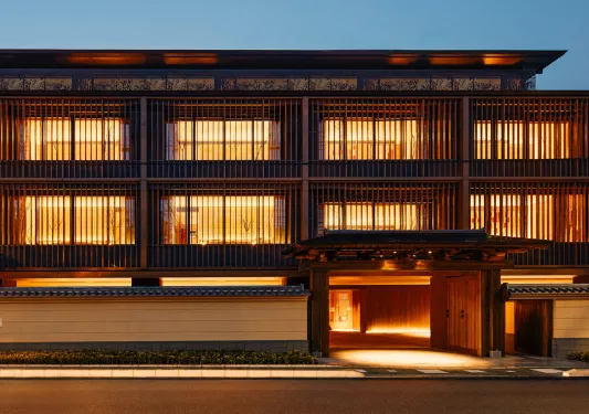 Exterior view of Japanese building with illuminated rooms and a road in front