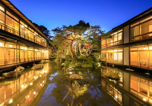 Exterior view of a small pong in front of a Japanese-style hotel building