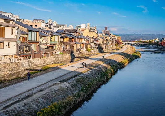 Road along a large river with houses to the left