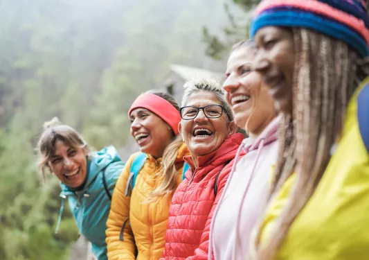 Group of women wearing jackets, smiling and looking at each other