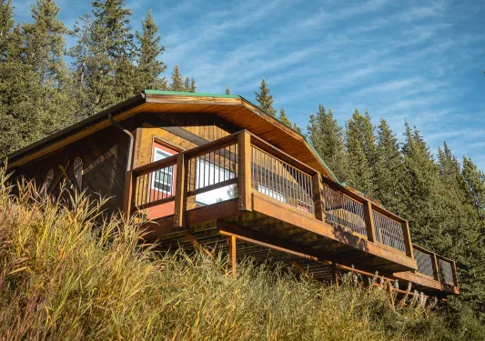 Exterior view of wooden cabin building with a wooden balcony