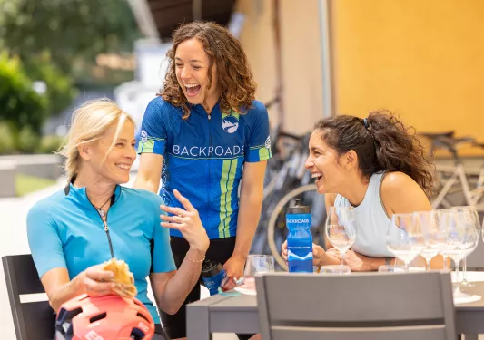 Three women smiling around a gray table