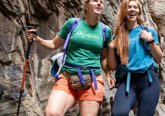 Two women hiking with large canyons behind them