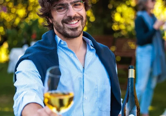 Man smiling while holding a glass of wine