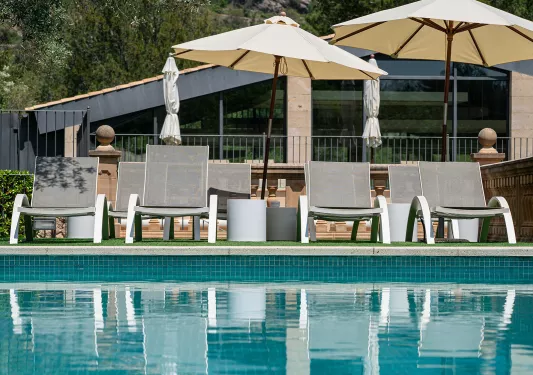 Outdoor pool with gray chairs and white umbrellas