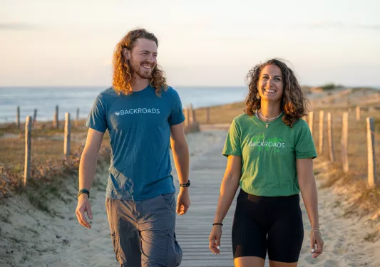 Man and woman smiling in front of a beach