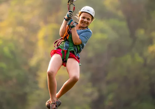 Girl smiling while riding on a zip line