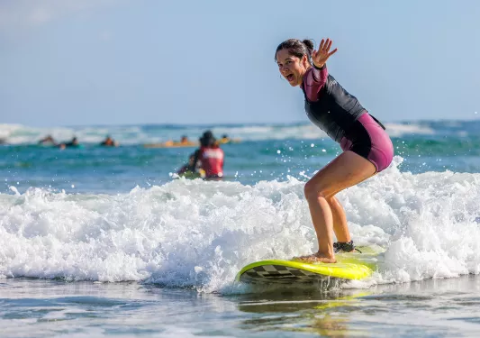 Woman standing on a surfboard in the ocean