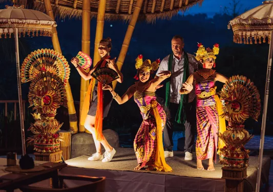 Group of people on a stage with two women wearing traditional attire