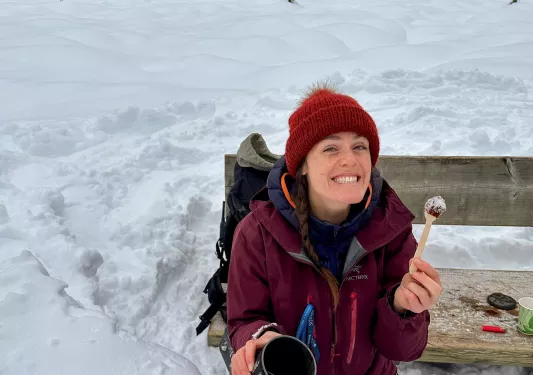 Women wearing red, sitting down playing in the snow