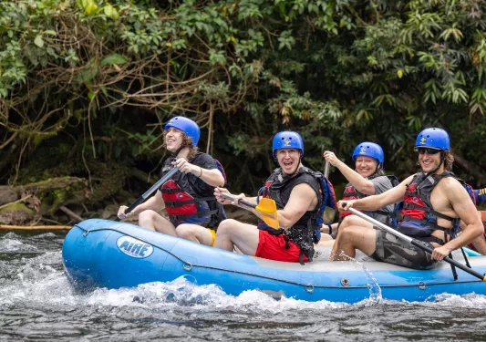 Three Backroads guests whitewater rafting