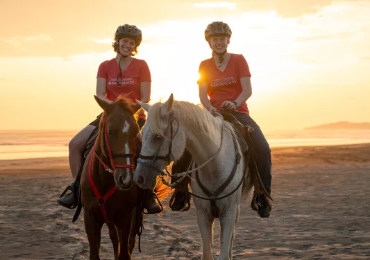 Two women smiling while horseback riding