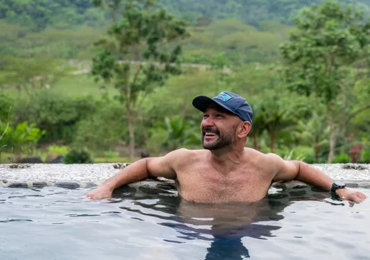 Man smiling while sitting in a hot spring
