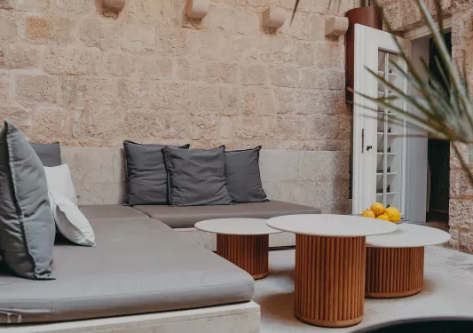 Outdoor patio with gray sofas and three circular tables