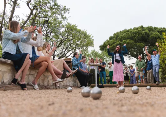 Group of people laughing while playing bocce ball