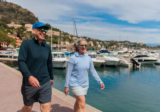 Man and woman walking on a boat dock by the water