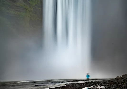 Large waterfall with a person looking at it from a distance