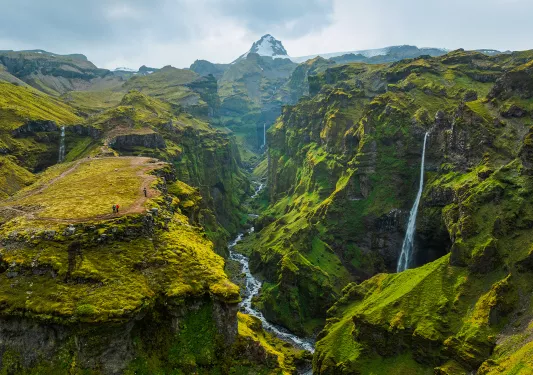 Tall mountains covered in grass and moss, with small waterfalls coming out