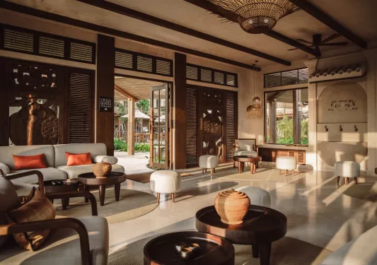 Hotel lobby room with cushioned, gray chairs and wooden walls