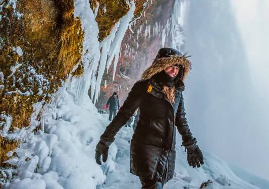 Woman wearing a snow jacket walking through a snowy path
