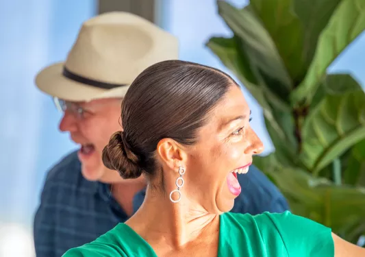 Woman in a green dress, laughing and smiling while dancing