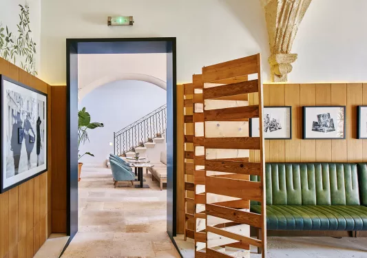 Hallway leading to another room with cushioned chairs and a staircase