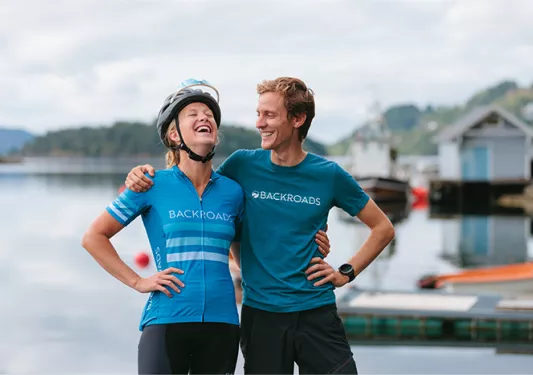 Two people laughing by body of water in Norway 