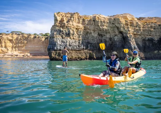 Two women laughing while paddling on a kayak