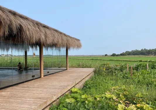 Room and hut with large windows, looking out to a large valley