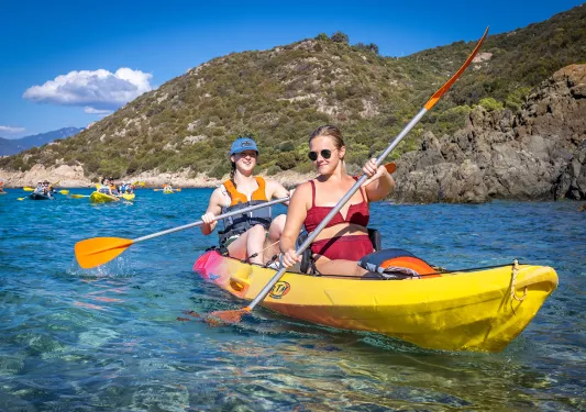 Two women paddling in a yellow kayak