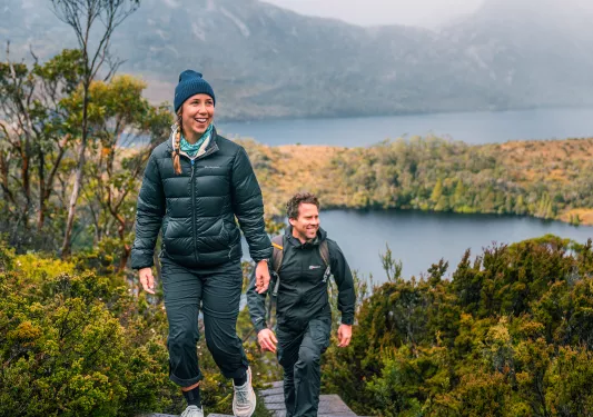 Man and woman ascending a staircase in the middle of a hill