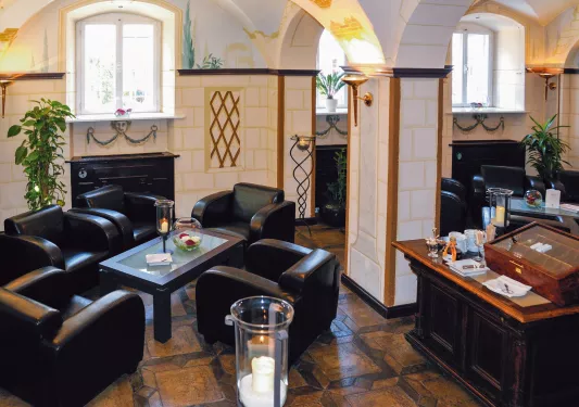 Hotel lobby with black, leather chairs around smaller coffee tables