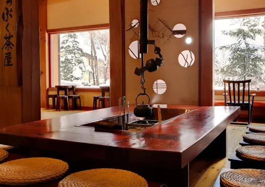 Rectangle dining table with a kettle handing from a metal pipe in the ceiling