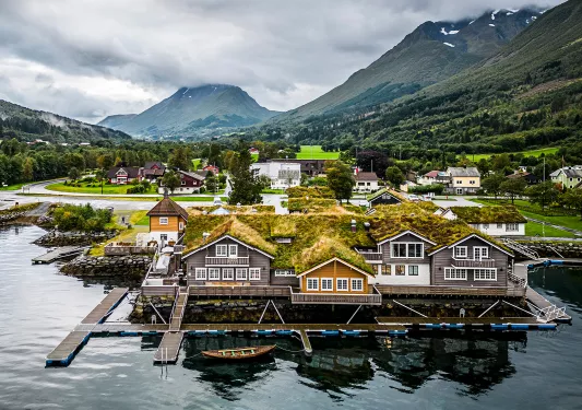 Exterior view of boat houses with large mountains in the background