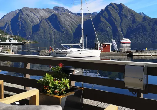 Dock with boats parked on the shore and mountains in the background