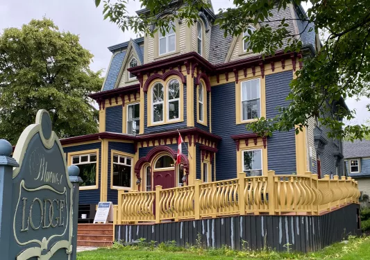 Exterior view of blue and yellow hotel building with a yellow gate in front