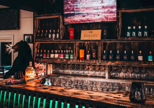 Bar and lounge with a counter and alcohol and spirits on the wall