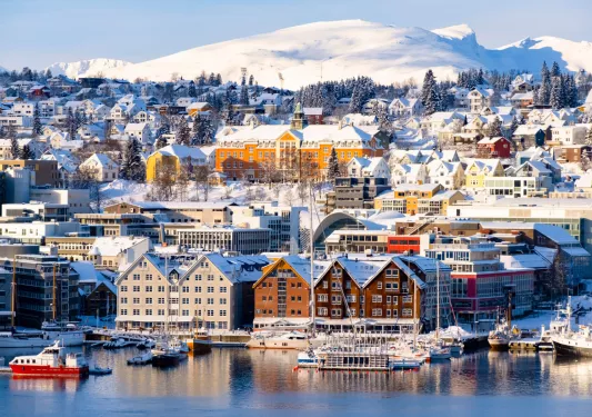 Wide view of a town, covered with snow and a lake in front