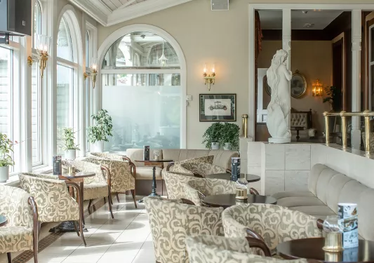 Indoor lounge and dining table with cushioned chairs and ceramic statues