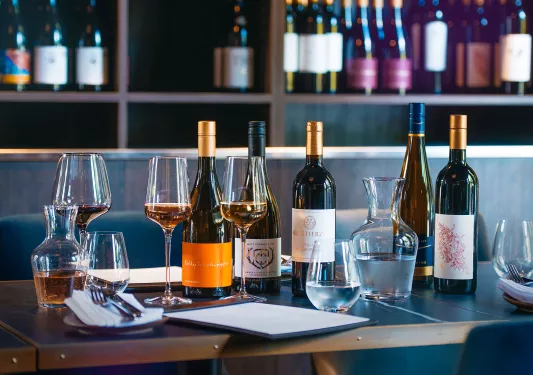 Row of wine bottles on top of a wooden table