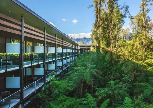 Exterior view of a multi-level building with balconies with glass barricades